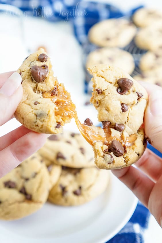 These Peanut Butter Caramel Stuffed Chocolate Chip Cookies are a bit of a mouthful, but a super delicious one! Soft peanut butter pudding cookies stuffed with soft caramels and loaded with chocolate chips! The first batch is ready in less than 30 minutes!