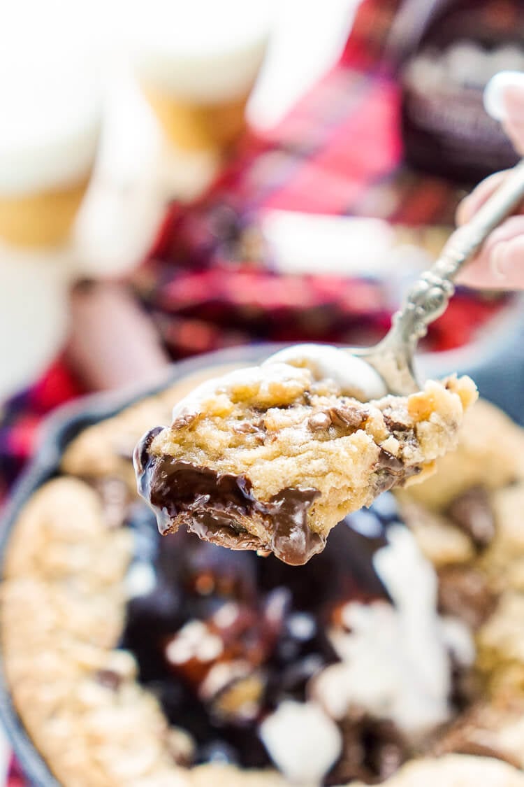 This Chocolate Toffee Skillet Cookie is the ultimate family dessert! Layers of chocolate and bits of toffee are folded into a cookie that's baked in cast iron and topped with ice cream and hot fudge.