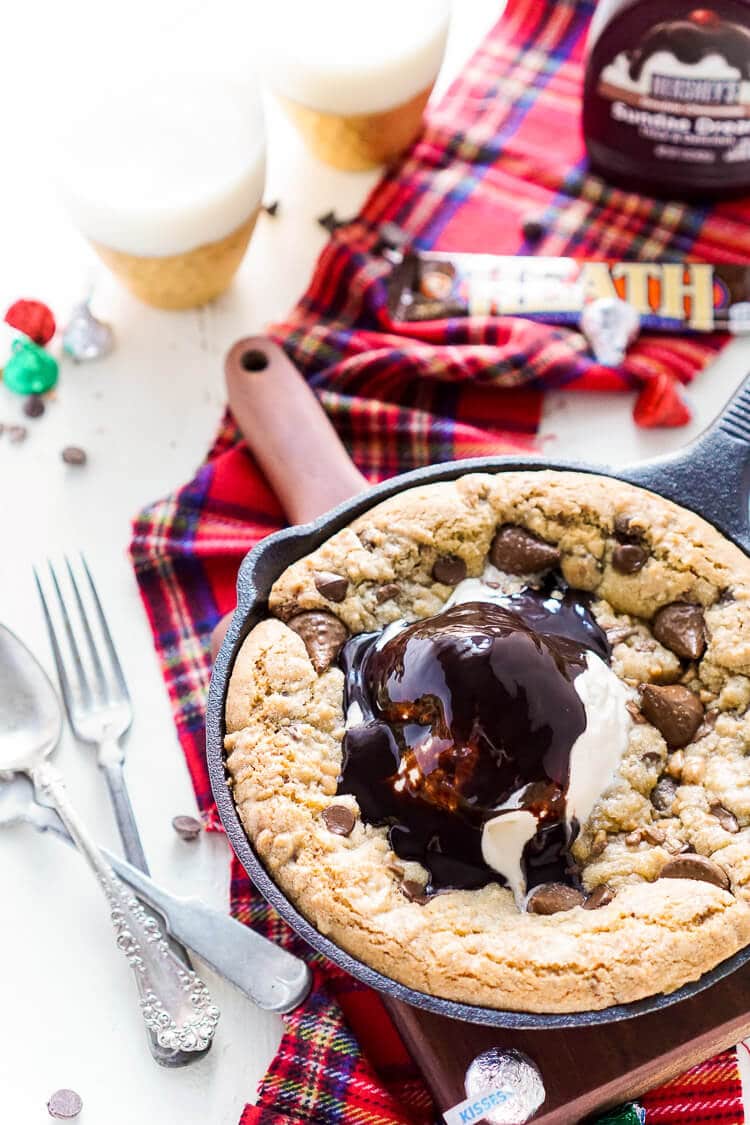 This Chocolate Toffee Skillet Cookie is the ultimate family dessert! Layers of chocolate and bits of toffee are folded into a cookie that's baked in cast iron and topped with ice cream and hot fudge.