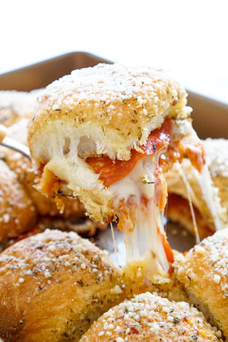 These Easy Pizza Sliders are so simple to make and are sure to be a family favorite! Layers of sauce, mozzarella, bacon, and pepperoni are baked in soft dinner rolls coated in butter, herbs, and parmesan!