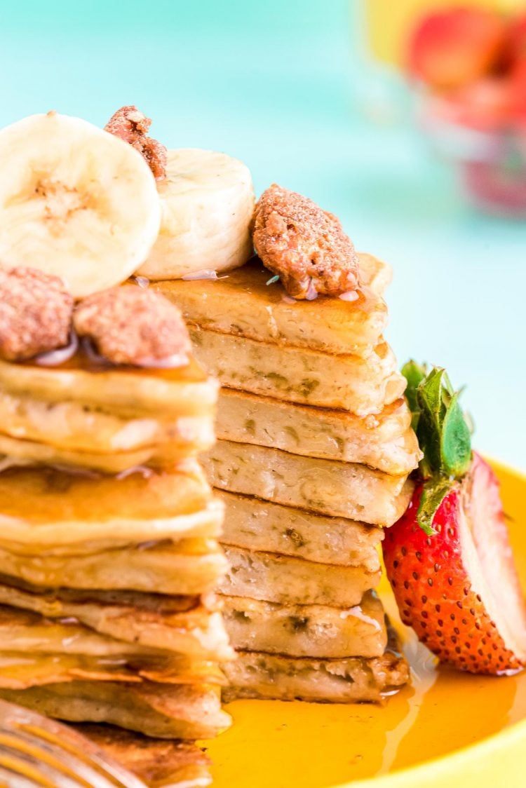 Close up photo of banana pancakes with a slice taken out of the stack.