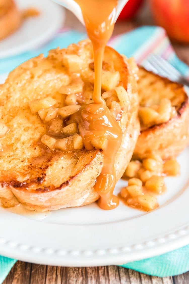 Caramel sauce being poured over french toast stuffed with apples