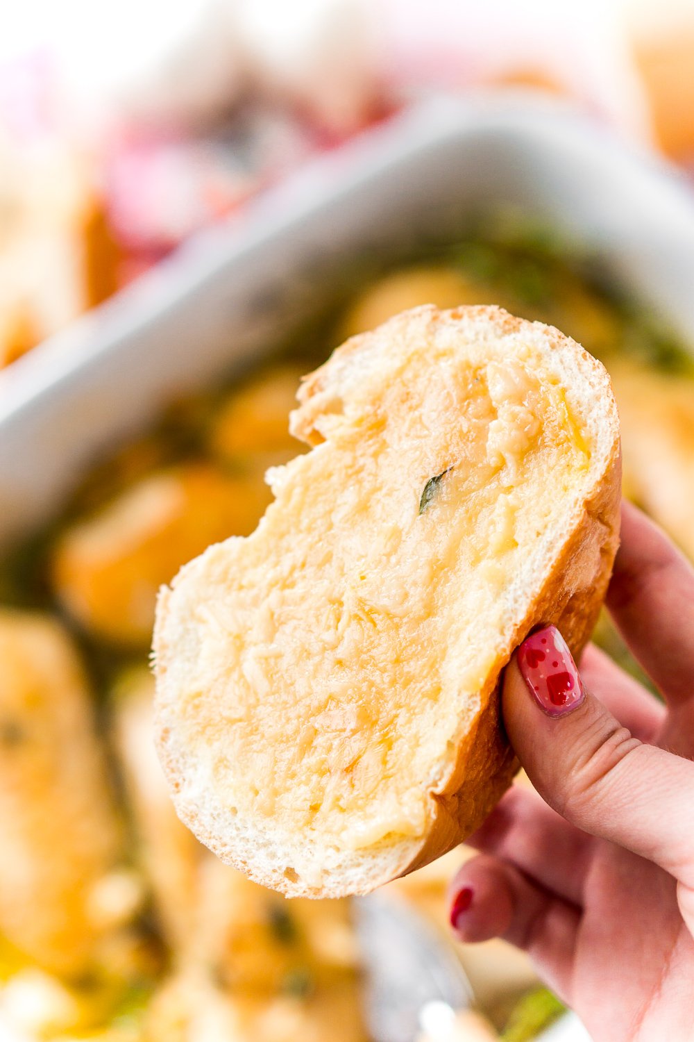 Piece of bread with roasted garlic spread on it leftover from garlic chicken.