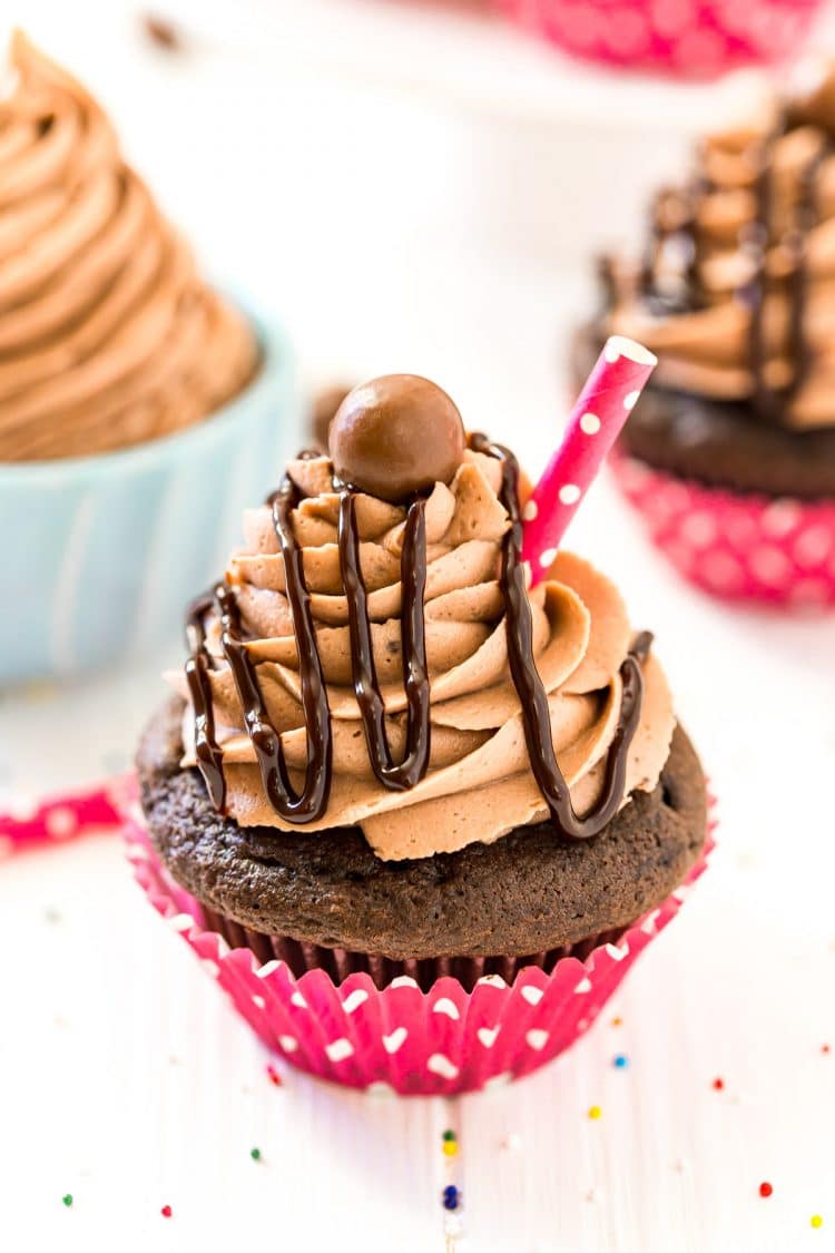 Chocolate cupcake topped with chocolate drizzle and whopper candy.