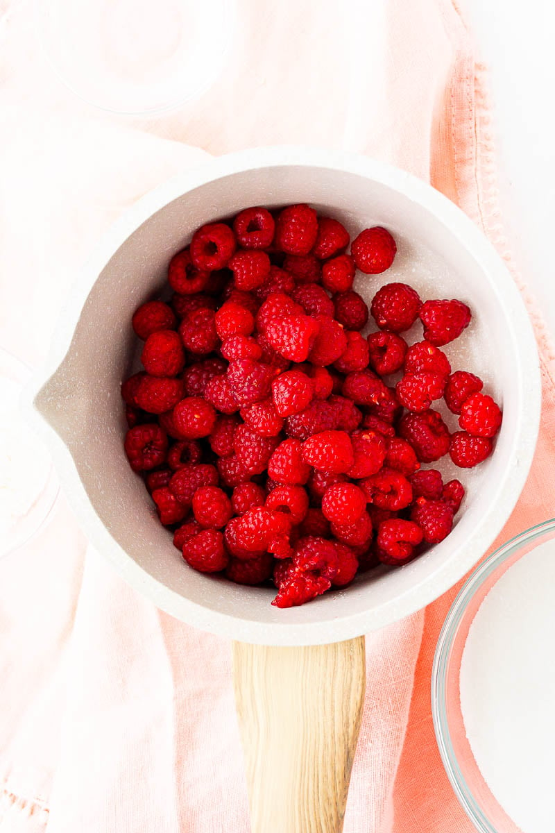 Fresh raspberries in a small saucepan.