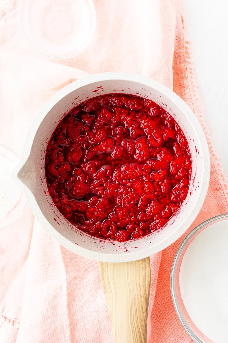 Raspberries that have been simmering in a small saucepan.