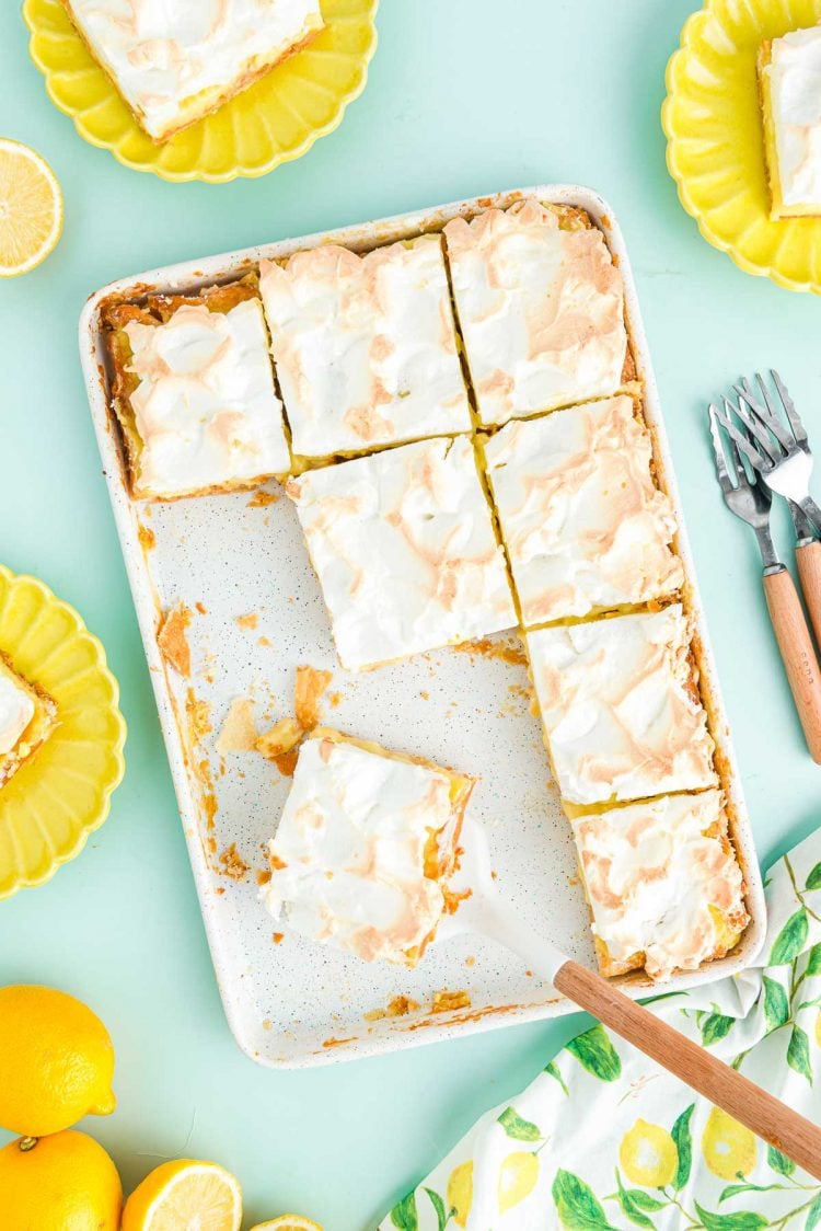 Overhead photo of lemon meringue slab pie on a blue surface.