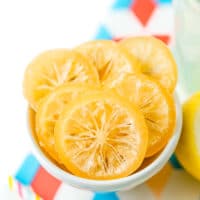 Sliced of candied lemons in a small white bowl.