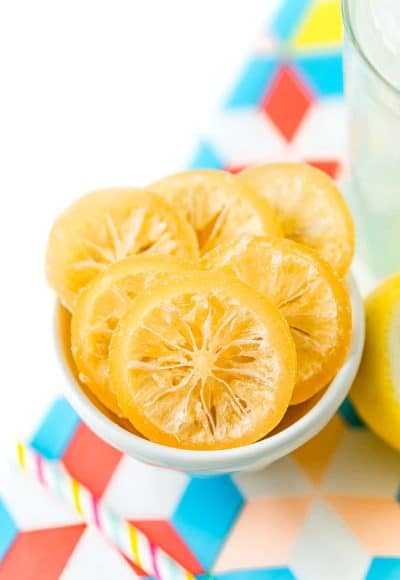 Sliced of candied lemons in a small white bowl.