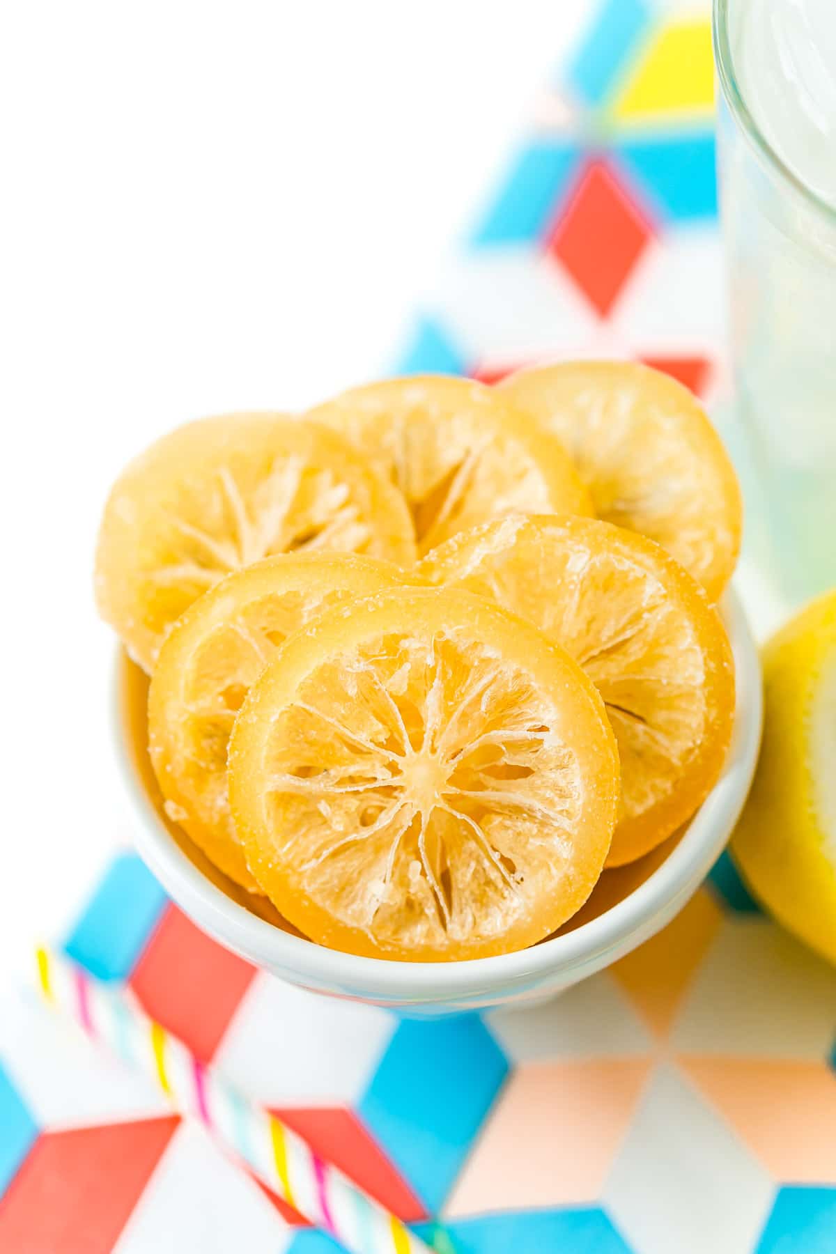 Sliced of candied lemons in a small white bowl.