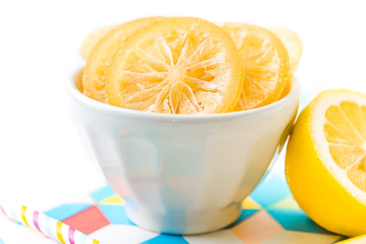 Close up photo of candied lemon slices in a small white bowl.