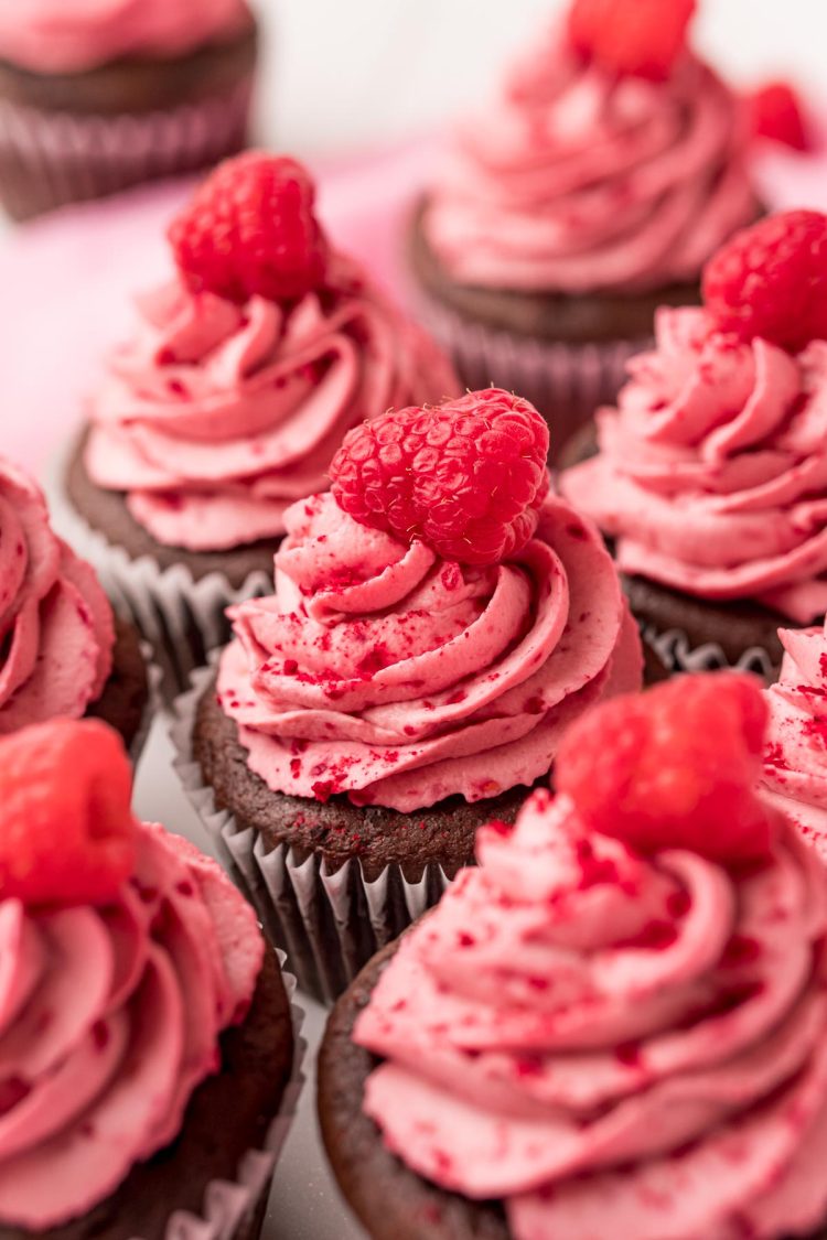 Close up photo of a chocolate cupcakes topped with raspberry frosting.