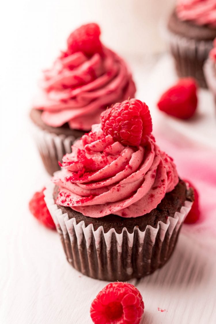 Close up photo of a chocolate cupcakes topped with raspberry frosting.