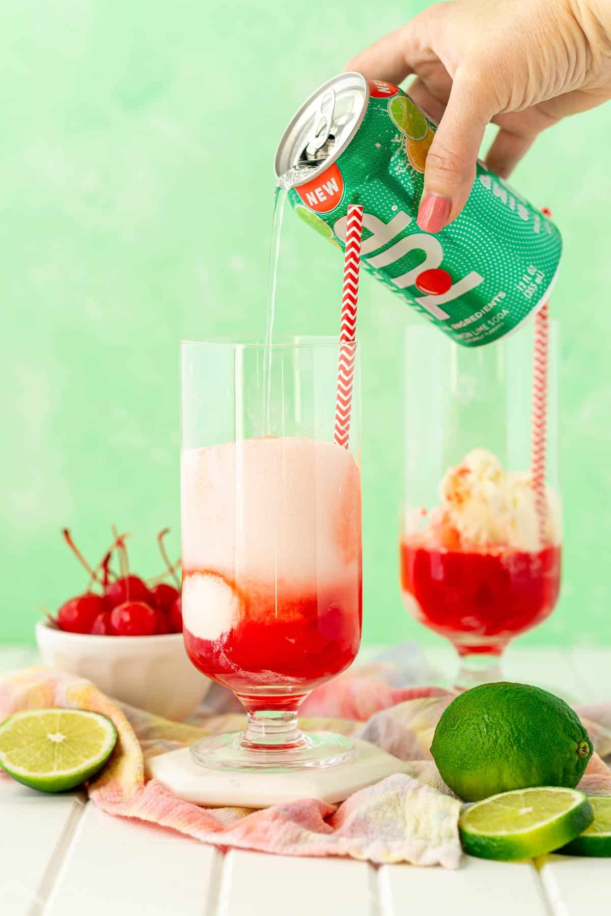 A can of 7Up being poured into a glass with vanilla ice cream and grenadine syrup.