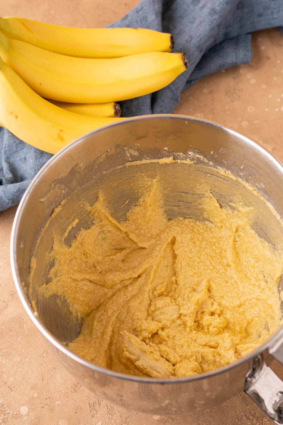 Butter, eggs, sugar, mixed to make cookie dough in a stand mixer bowl.