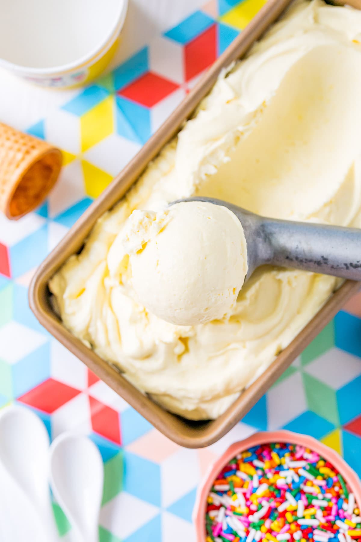 Ice cream scoop scooping vanilla ice cream.