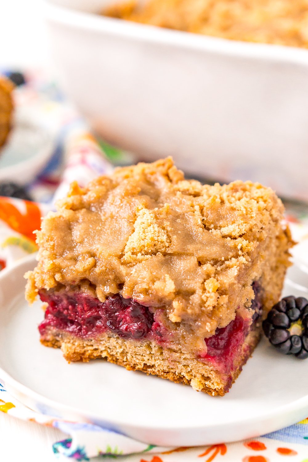 Slide of BlackBerry Coffee cake on a plate with a single blackberry