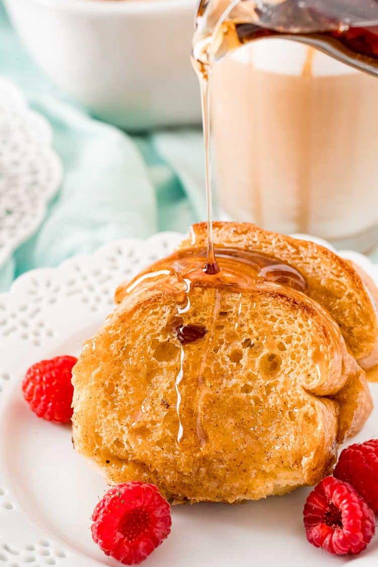 Syrup being poured over Caramel Macchiato French Toast on a white plate.