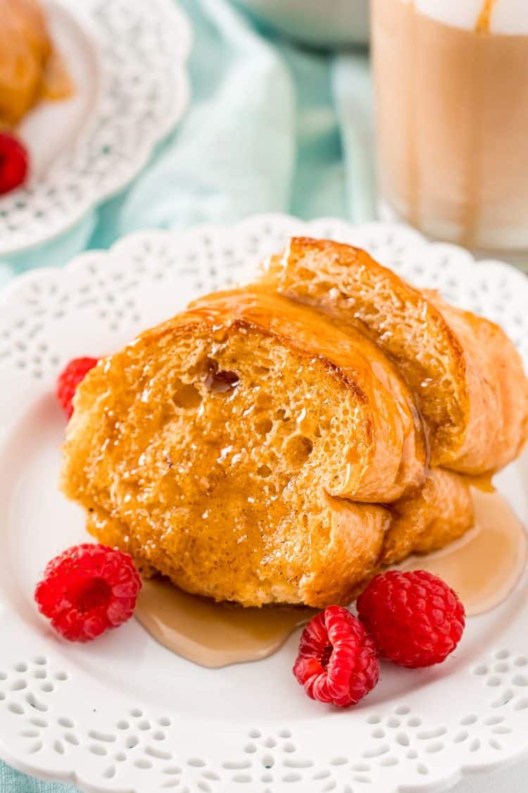 Slices of Caramel Macchiato French Toast on a white plate with raspberries.