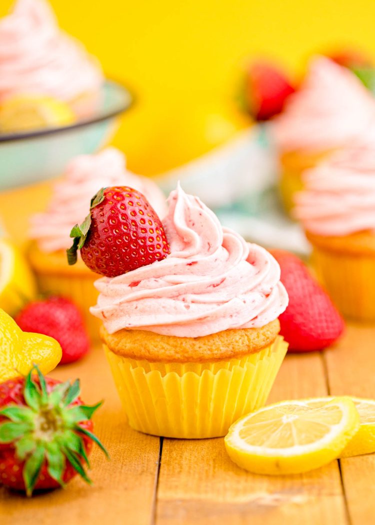 Close up photo of a lemon strawberry cupcakes on a wooden table.