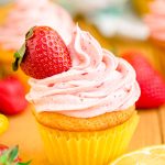 Close up photo of a lemon strawberry cupcakes on a wooden table.