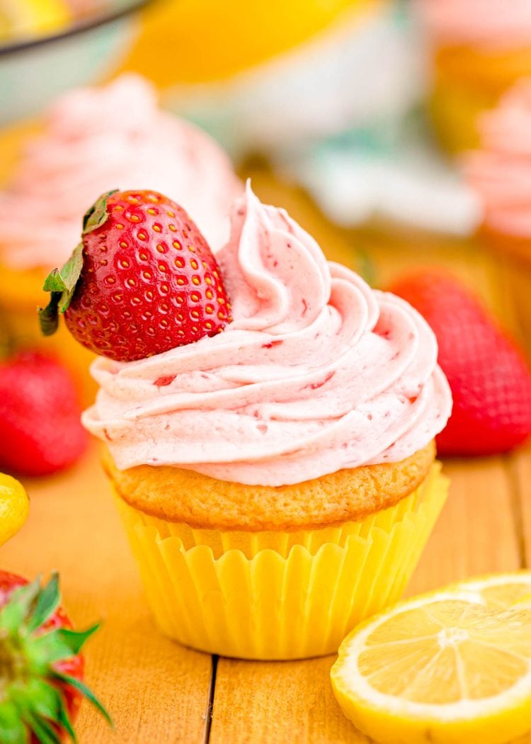 Close up photo of a lemon strawberry cupcakes on a wooden table.