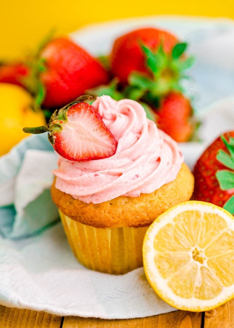 Close up photo of a lemon strawberry cupcakes on a wooden table.