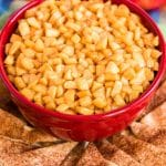 Caramel Apple Dip in a red bowl on a plate with pie crust chips.