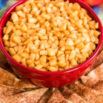 Caramel Apple Dip in a red bowl on a plate with pie crust chips.