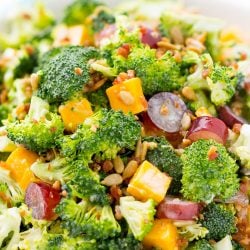 This Sweet Broccoli Salad is an easy, crunchy, and lightly sweetened side salad that's perfect for BBQs and more! Made with fresh broccoli, grapes, cheese, sunflower seeds, bacon, and a delightful dressing! Bring it to all your summer get-togethers!