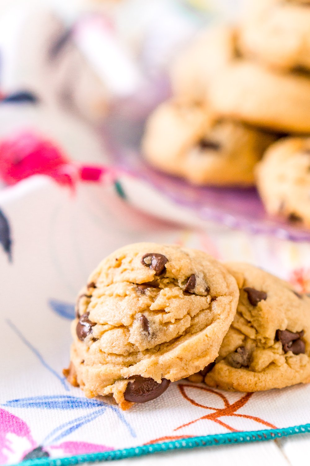 Two Peanut Butter Chocolate Chip Cookies on a floral napkin.