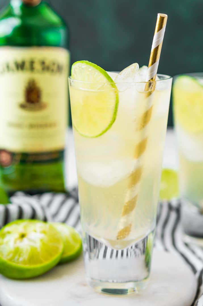 An Irish mule cocktail on a white coaster with a bottle of Jameson in the background.