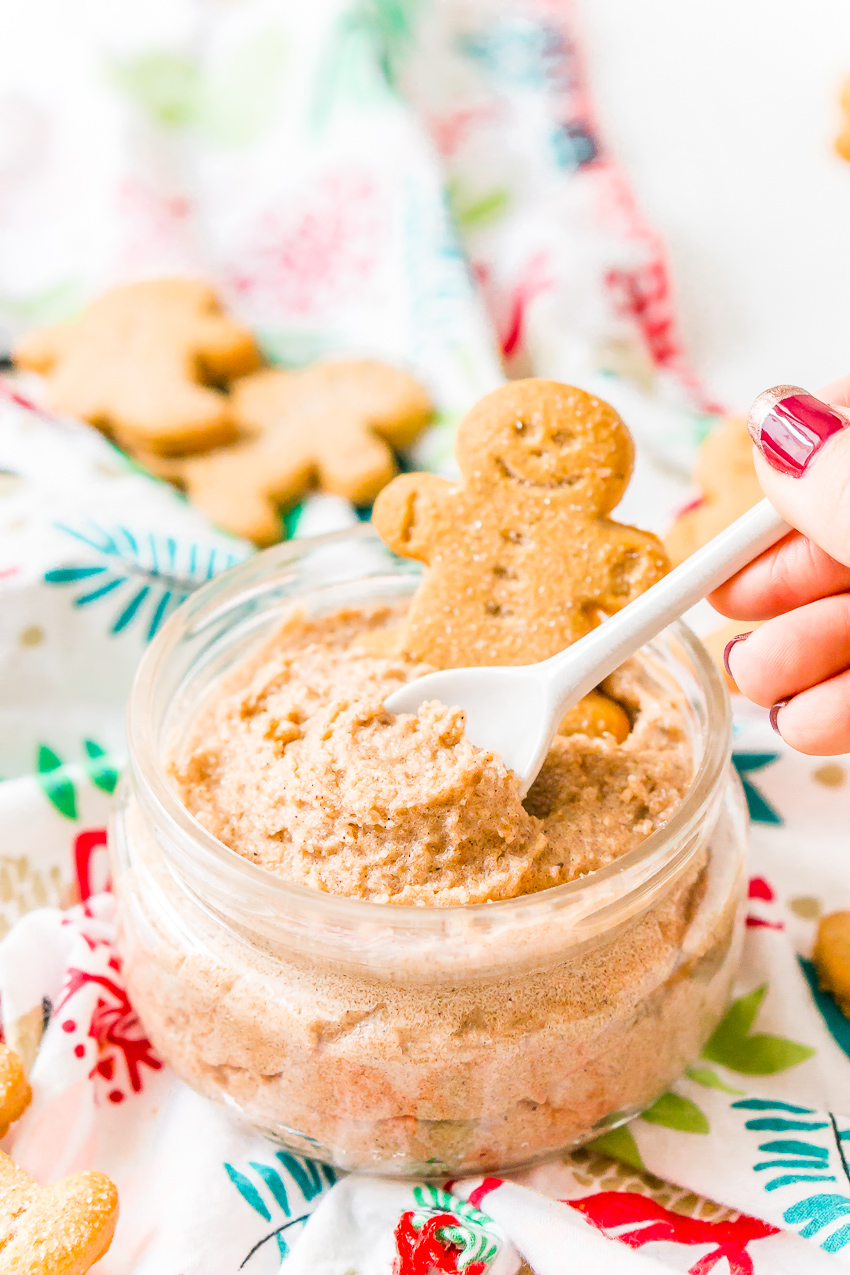 Spoon dipping into gingerbread scrub with gingerbread man in the jar