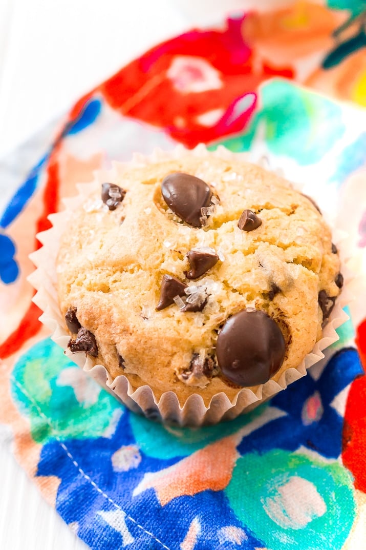 Close up photo of a chocolate chip muffin on a colorful napkin.