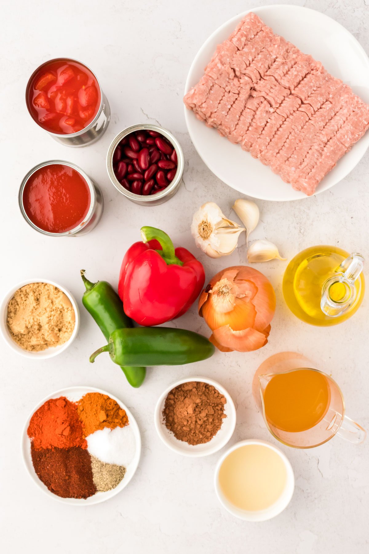 Overhead photo of ingredients to make turkey chili prepped on a white counter.