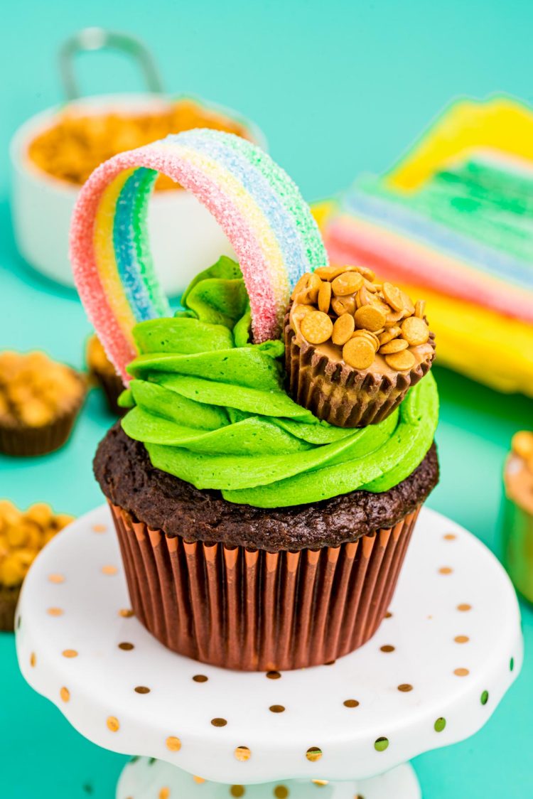POT OF GOLD ST PATRICKS CUPCAKE WITH GREEN FROSTING, RAINBOW CANDY AND POT OF GOLD REESES AND SPRINKLES easy green desserts for St Patricks Day. Get tons of dessert ideas from decadent, no bake, easy, vegan and green!