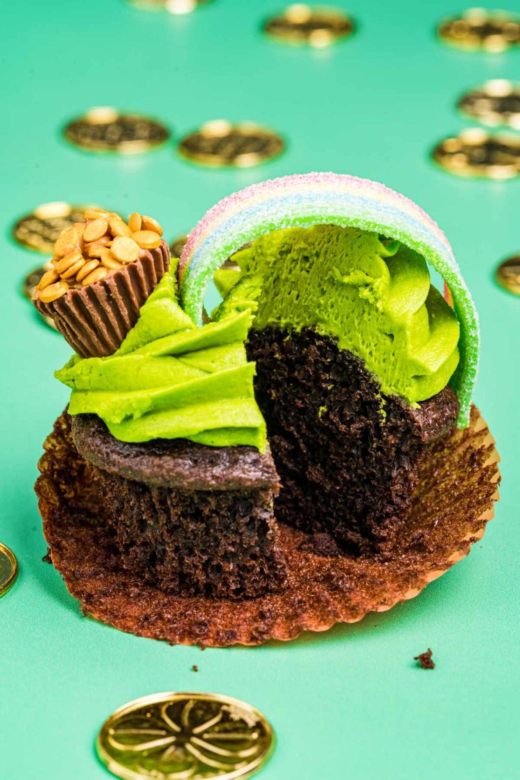 Pot of gold decorated cupcake that has been sliced in half.