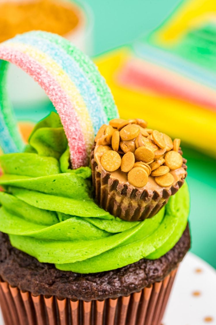 Close up photo of cupcakes frosted and decorated to look like a rainbow and pot of gold.