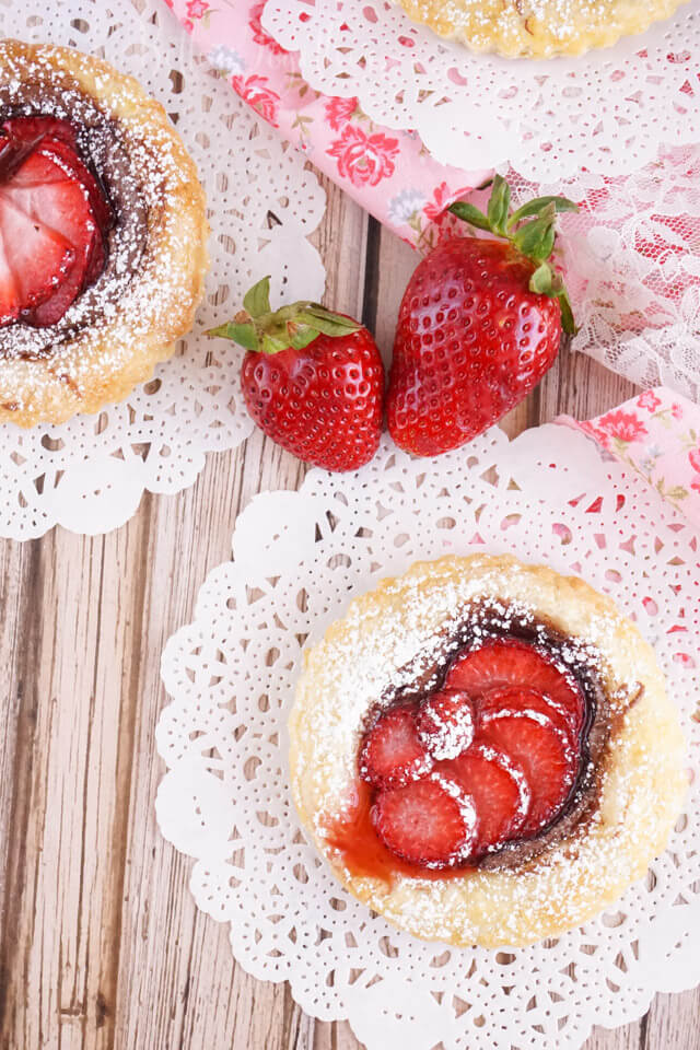 These Strawberry Nutella Tarts inspired by The Selection Series are so simple to make. Rich and creamy Nutella and tart strawberries in a flaky pastry dusted in sugar - they're absolutely divine!