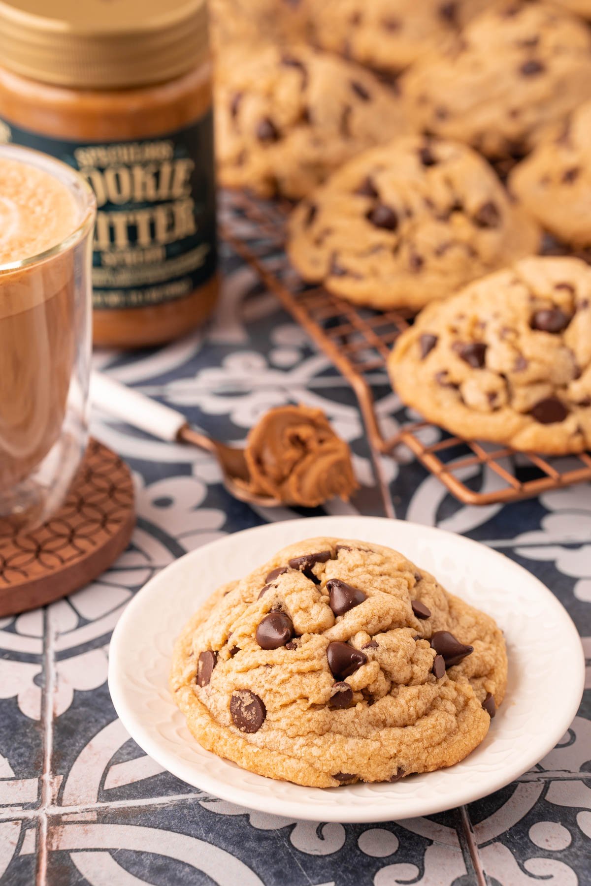 Cookie butter chocolate chip cookies on a white plate and cooking rack.