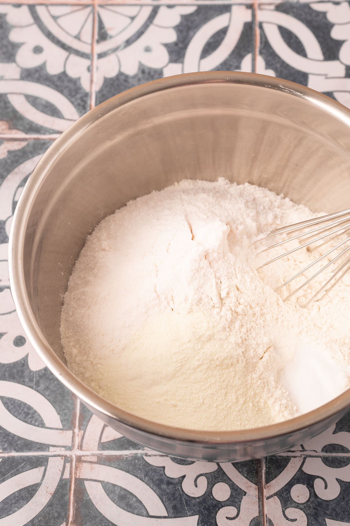 Flour and other dry being ingredients being whisked in a bowl.