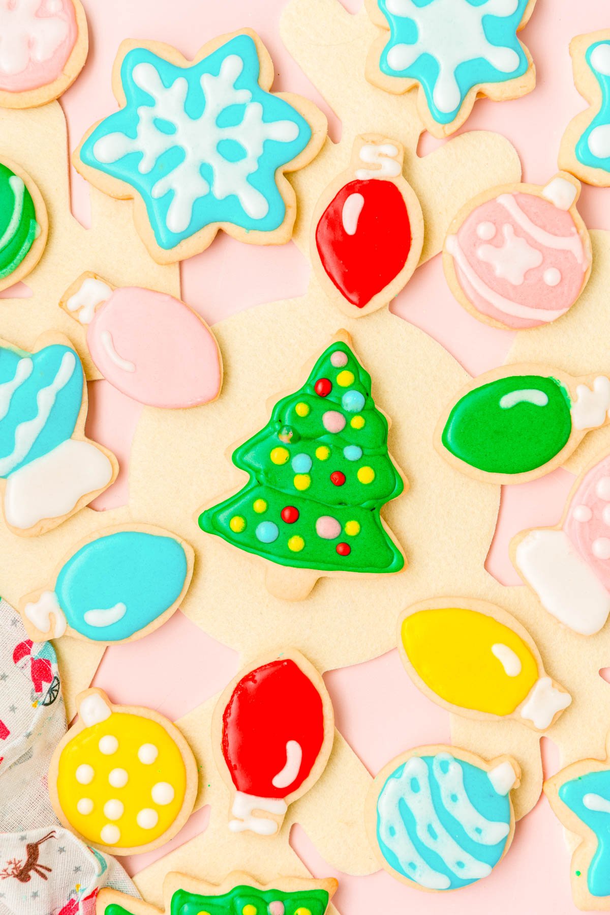 Overhead photo of iced christmas sugar cookies on a table.