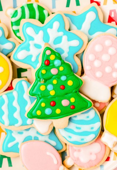 Royal iced sugar cookies for Christmas piled on a plate.