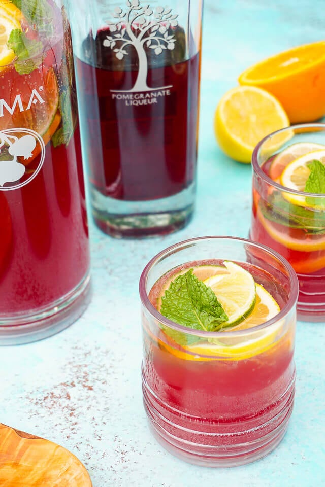 Celebrate summer with this Pomegranate Citrus Rum Punch! Sweet PAMA Pomegranate Liqueur paired with lemonade, lemon lime soda, and rum for a splash of summer fun. Plus a recipe video!