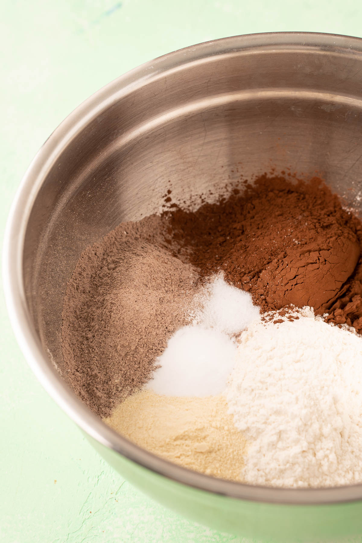 Dry ingredients to make chocolate rocky road cookies in a metal mixing bowl.