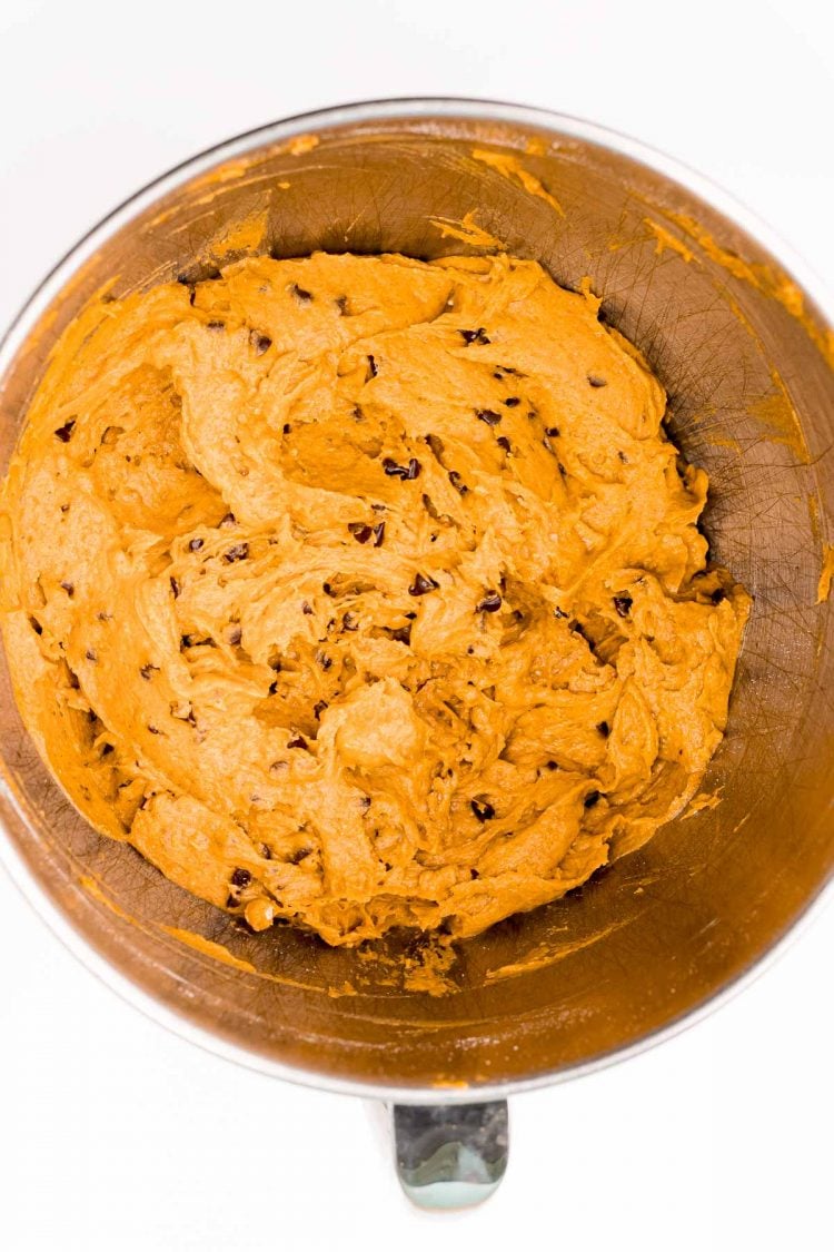 Overhead photo of mixing bowl filled with pumpkin chocolate chip cookie dough.