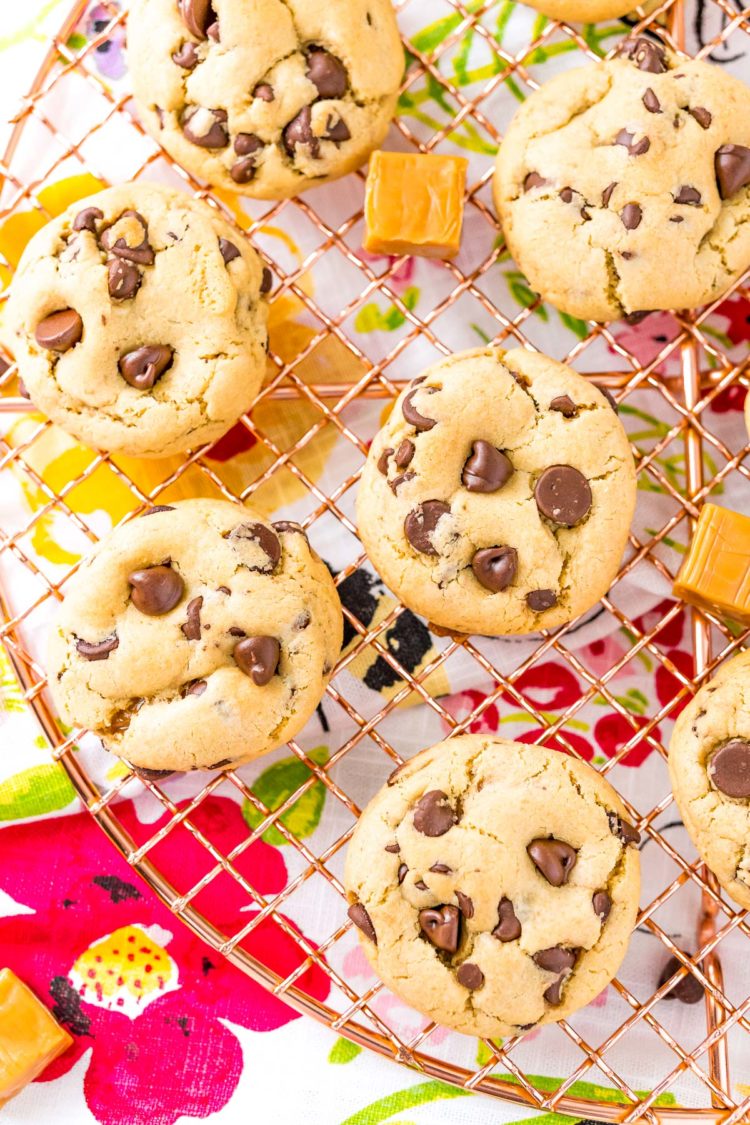 Overhead photo of chocolate chip cookies with caramel on a cooling rack.