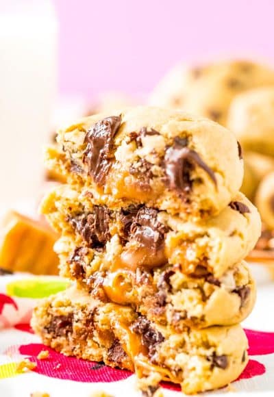 Close up photo of chocolate chip cookies stacked on top of each other that have caramel centers.