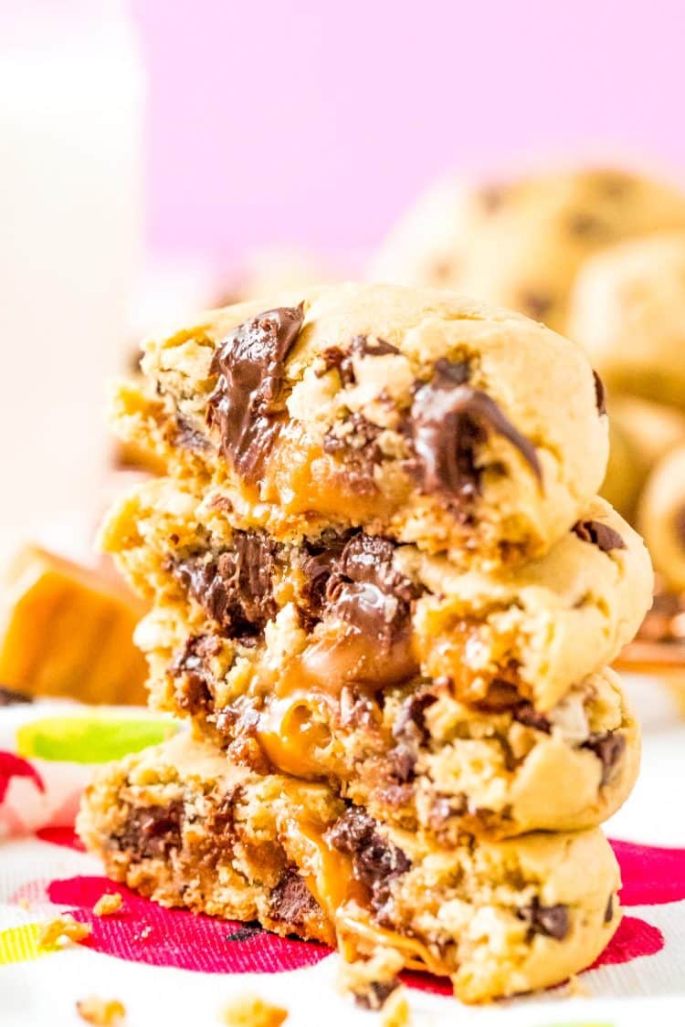 Close up photo of chocolate chip cookies stacked on top of each other that have caramel centers.