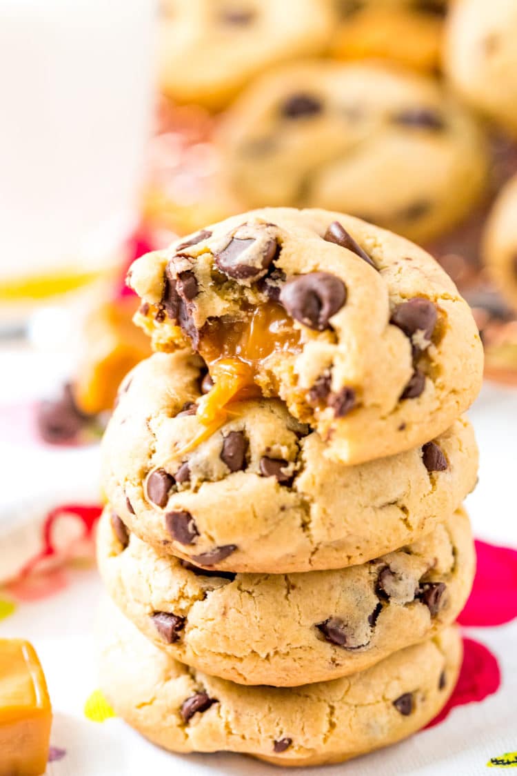Close up photo of a stack of four chocolate chip cookies that have been stuffed with caramel.